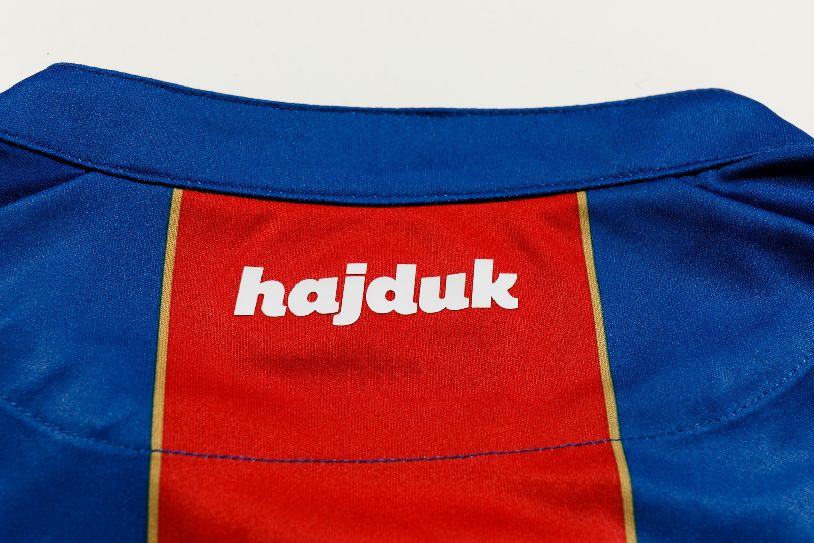 The Hajduk Split Away shirt 2017/18 has vertical red and blue bands with  gold details. The Macron logo stands out in white on the top right-hand  side of, By Macron